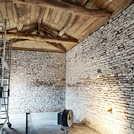 rénovation d'un mur en pierre avec sablage et aérogommage charpente intérieure